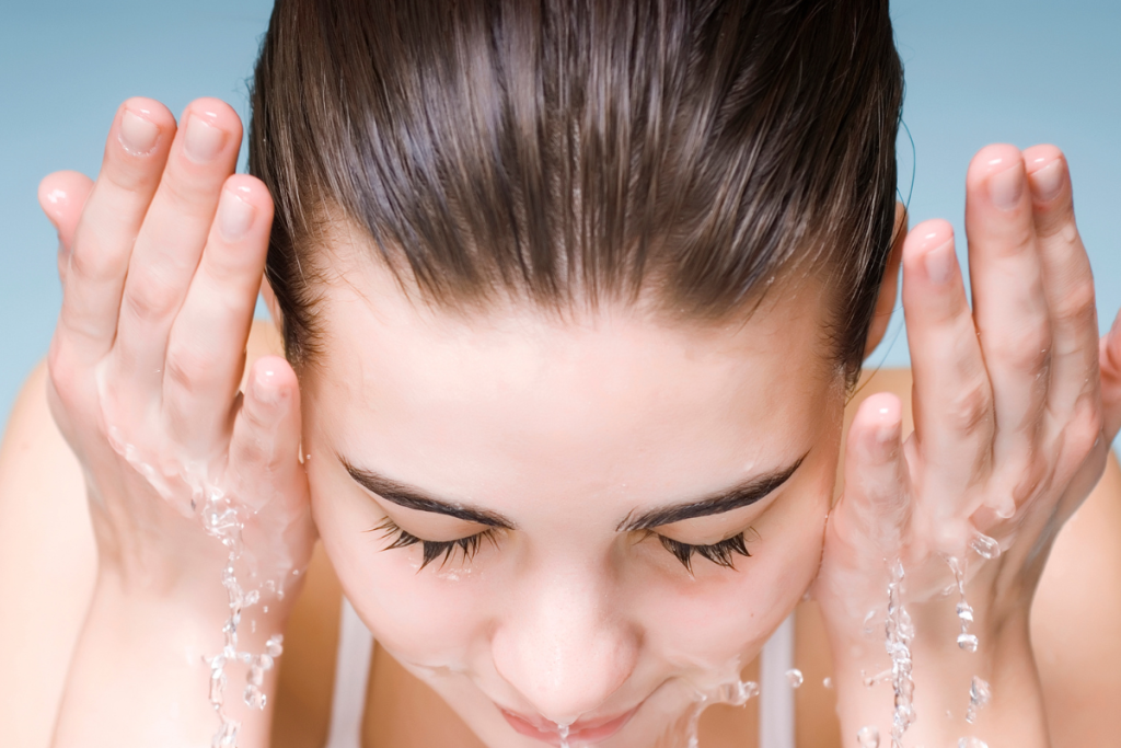 a woman cleansing her face to illustrate the double cleansing technique for removing makeup